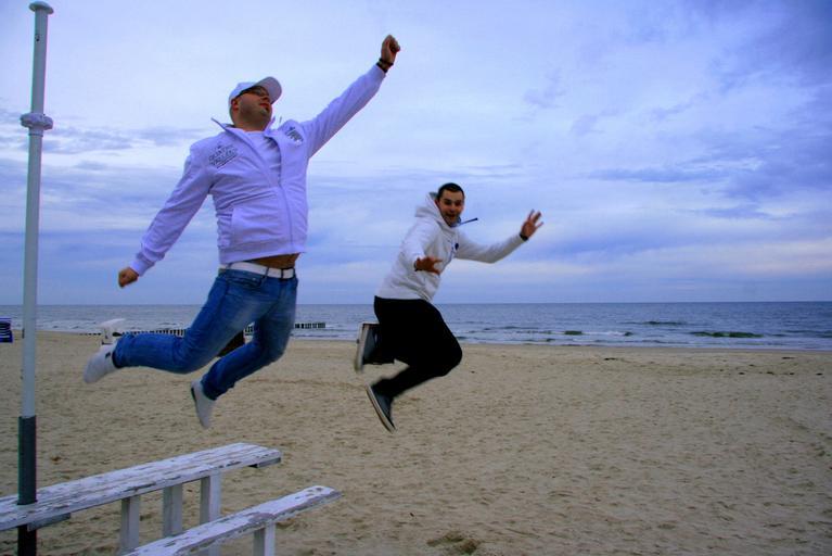 dva skákající muži na pláži