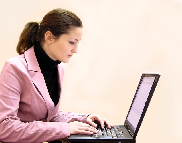 mladá žena pracující u počítače v kanceláři